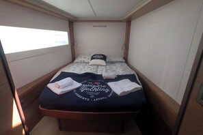 A small, compact room with a bed, a pillow, and a towel. - Sun-kissed Sailing Adventure in Split-Dalmatia, Croatia (Seget Donji)