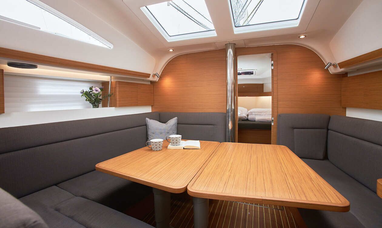 Een modern interieur met een centrale tafel, comfortabele zitmogelijkheden en dakramen.