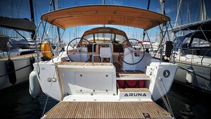 A yacht named 'ARUNA' docked in a marina with other boats, featuring a wooden deck and a covered seating area. - Sun-Kissed Sailing Adventure in Zadar, Croatia (Biograd na moru)