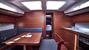 A compact kitchen with a dining area, a small sleeping berth, and a window for natural light. - Sun-Kissed Sailing Adventure in Zadar, Croatia (Biograd na moru)