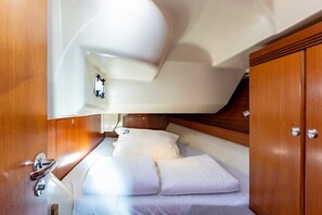 A compact cabin with a bed, wooden cabinetry, and a small window. - Sun-Kissed Sailing Adventure in Northern Croatia (Punat)
