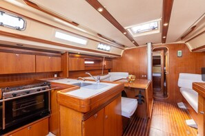 A compact galley with a stove, sink, and seating area.