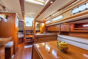 A compact galley with a sink, a small window, and a bowl of fruit on the counter. - Sun-Kissed Sailing Adventure in Northern Croatia (Punat)