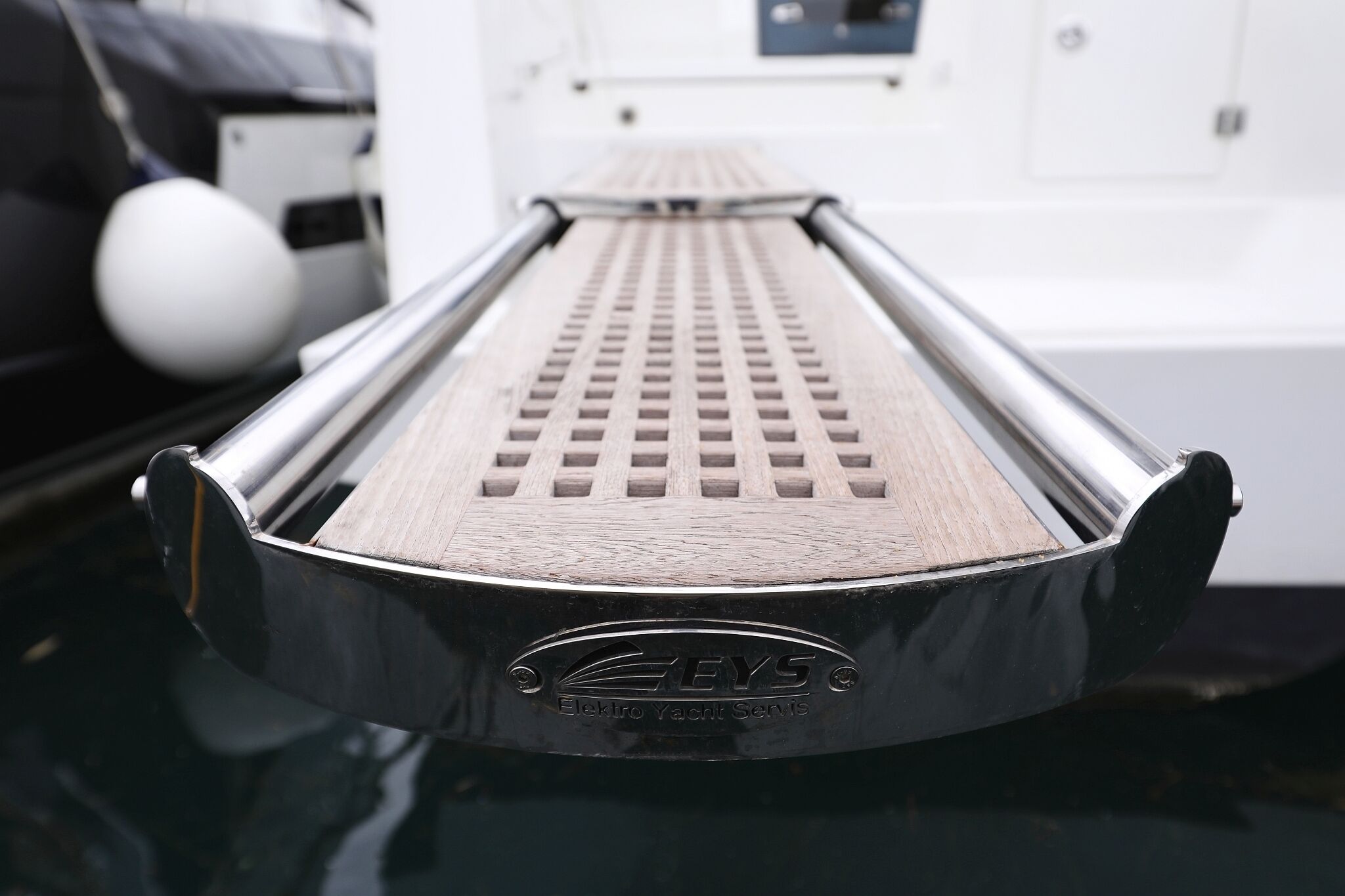 A close-up of a metallic, textured surface with a logo and text indicating 'EYS Electro Yacht Servis.'
