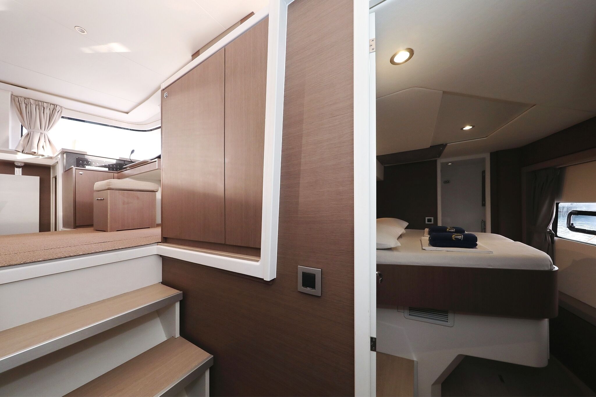 Een compact interieur met een bed, een zithoekje en een kitchenette.
