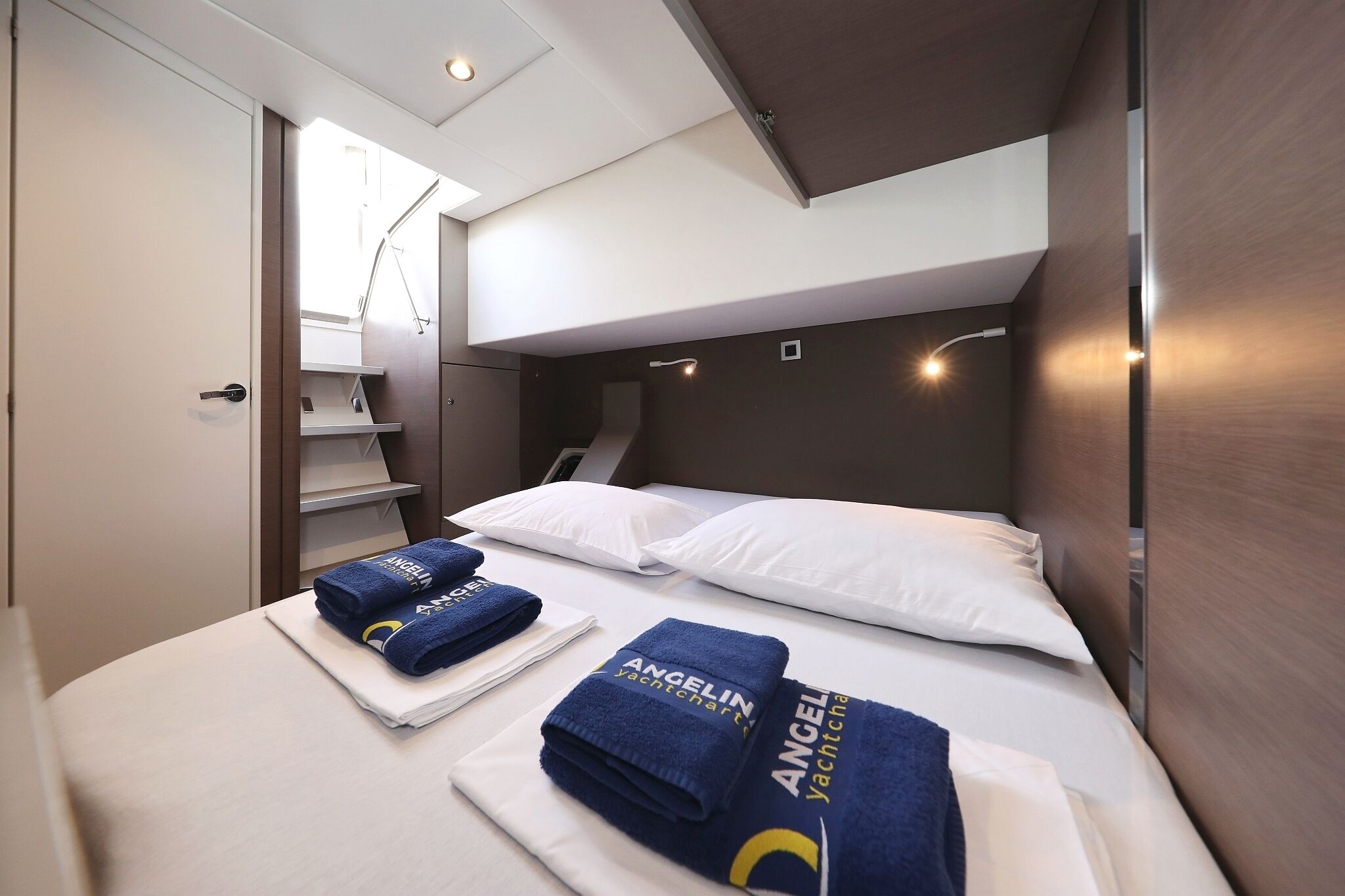 Habitación de hotel con cama, escritorio, silla, armario y ventana.