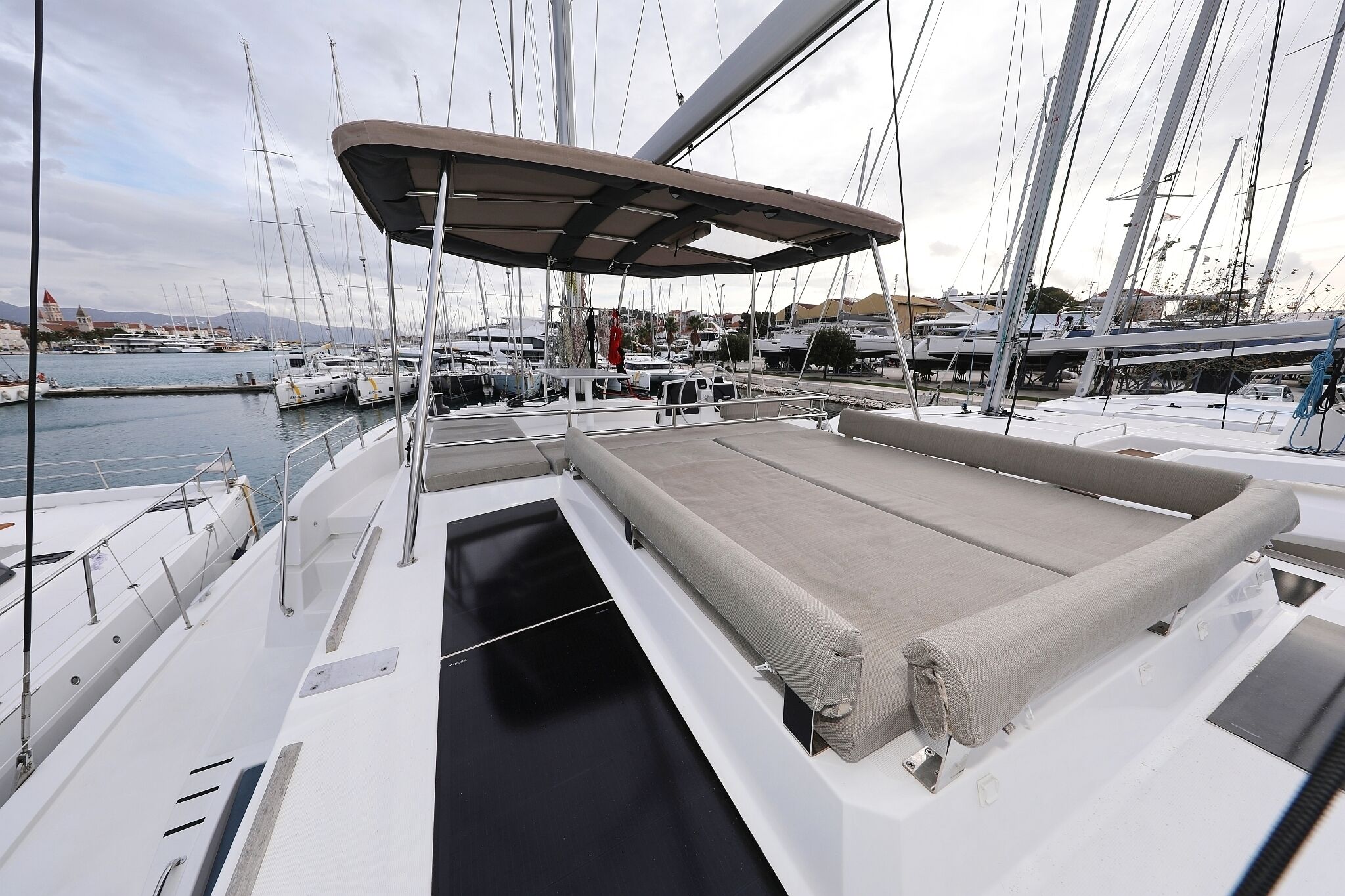 A marina with boats docked, a covered deck area, and a view of the water and distant land.