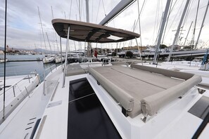 Een jachthaven met aangemeerde boten, een overdekt dek en uitzicht op het water en het land in de verte.