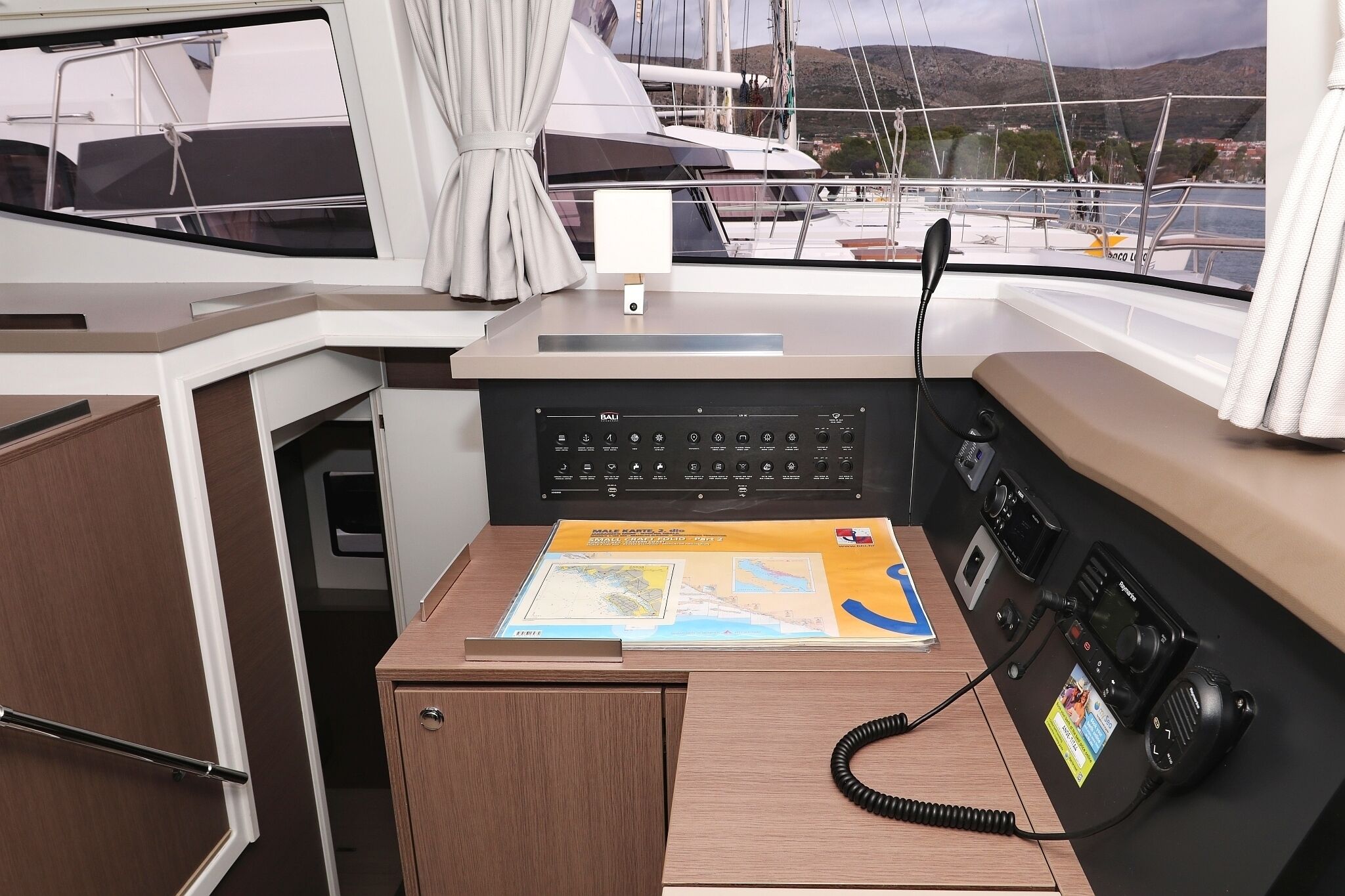 A boat's control station with a map, a radio, and a phone.