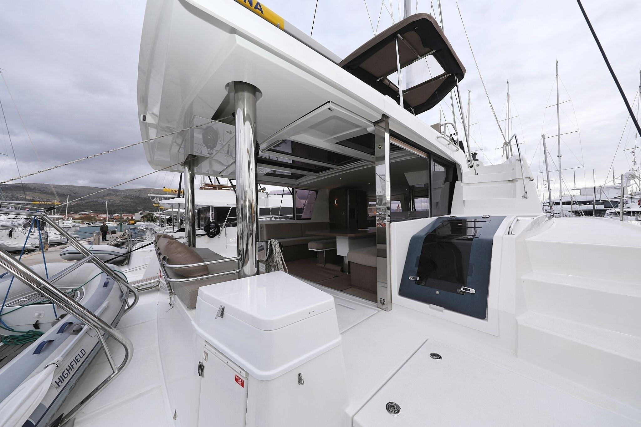 A boat deck with a seating area, a small table, and a sheltered space.