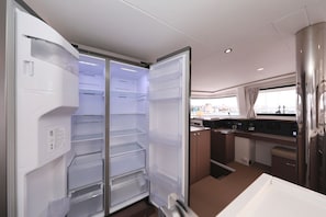 A modern kitchen with a built-in refrigerator, a window with a view, and a counter with a sink. - Sun-kissed Sailing Adventure in Split-Dalmatia, Croatia (Trogir)