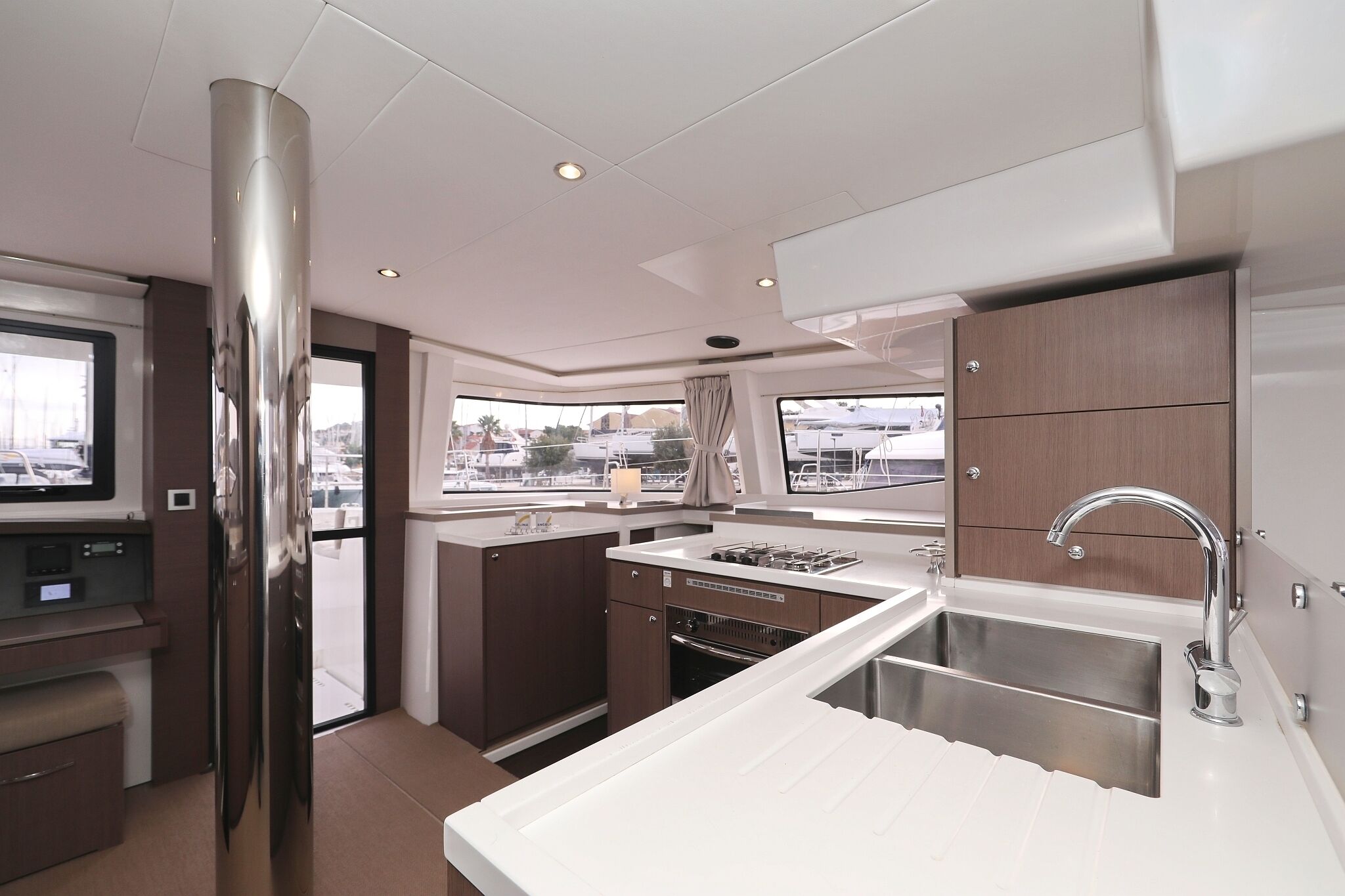 A modern kitchen with stainless steel appliances, a built-in oven, and a large window offering a city view.