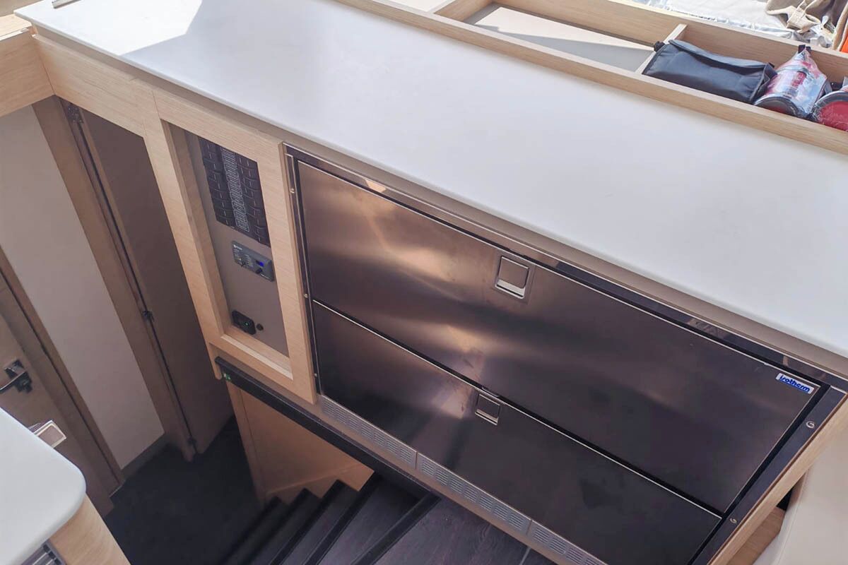 A compact kitchen with a stainless steel refrigerator, a built-in oven, and a small countertop.