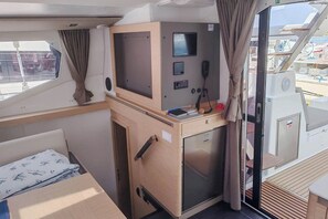 A compact galley with a refrigerator, a small sink, and a control panel with a screen and buttons. - Sun-kissed Sailing Adventure in Split-Dalmatia, Croatia (Seget Donji)