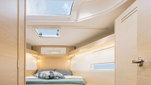 A compact, well-lit interior with a bunk bed, skylights, and a small desk area. - Sun-Kissed Sailing Adventure in the Dodecanese Islands (Rodos)