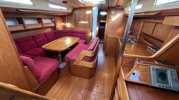A compact interior with a dining area, seating, and a small kitchenette.