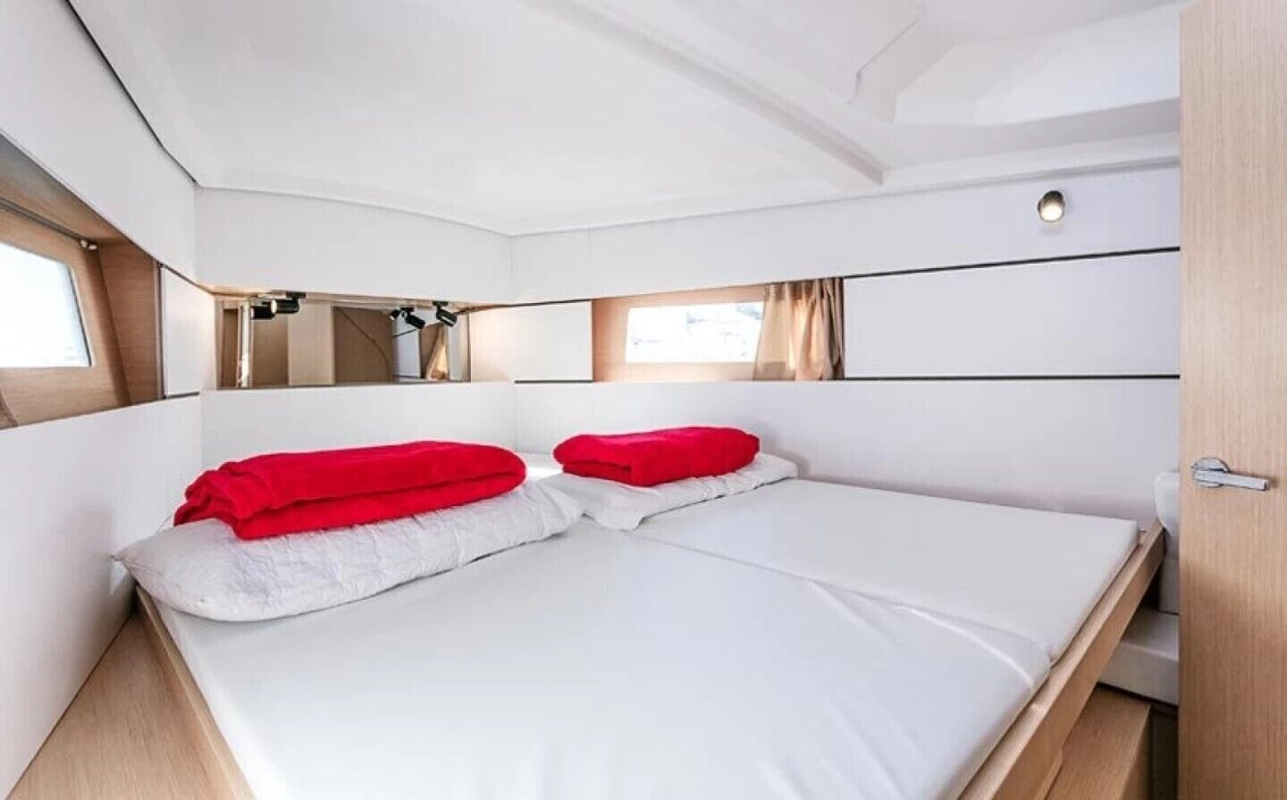 Una stanza piccola e luminosa con un letto, una finestra e una porta.