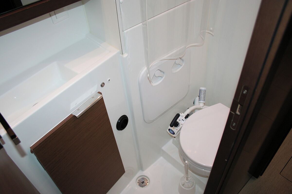 Une petite salle de bain comprenant des toilettes, un lavabo et une douche.