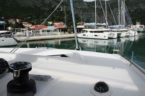 Ein Yachthafen mit vertäuten Booten, freie Wasserblick und Gebäude im Hintergrund.