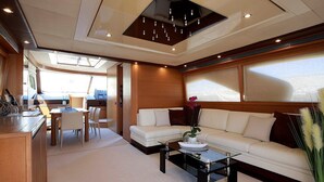 Ein Yacht-Interieur mit Essbereich, einer Couch und einem Couchtisch.
