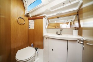 Ein kleines Badezimmer mit Toilette, Waschbecken und Spiegel.