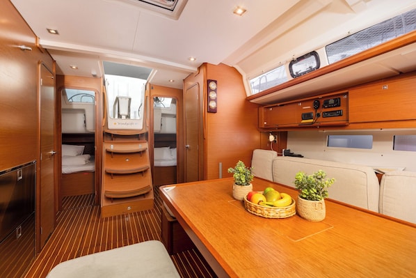 A compact, well-lit interior with a dining area, a small kitchenette, and a cozy seating area. - Sun-Kissed Sailing Adventure in Northern Croatia (Punat)