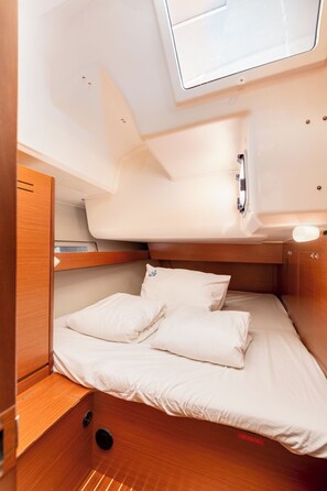 A compact, well-lit cabin with a bed, a small shelf, and a skylight. - Sun-Kissed Sailing Adventure in Northern Croatia (Punat)