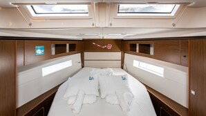 Een compacte, goed verlichte hut met een bed, dakramen en houten lambrisering.