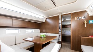 Een compact, modern interieur met een houten tafel, beklede zittingen en een bordje met de tekst 'Home' aan de muur.