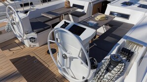 Ein Yachdeck mit Steuerpult, Bedienfeld und Sitzgelegenheiten.