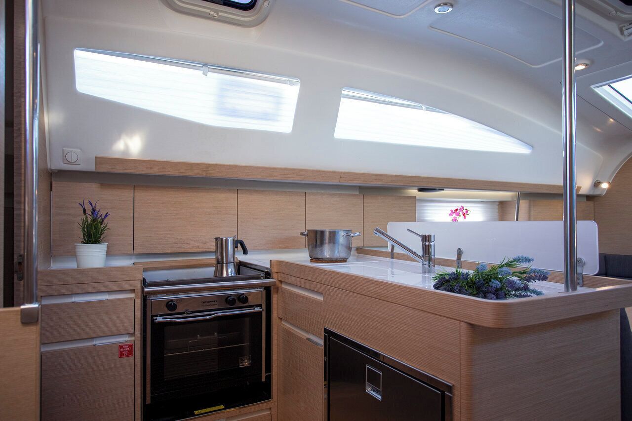 A compact kitchen with a stove, oven, sink, and a small countertop area.