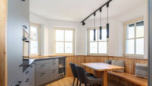 A modern kitchen with a wooden bench, built-in cabinets, and pendant lighting. - A beautiful apartment with its own terrace at Oberwinklgut. (Bischofshofen)