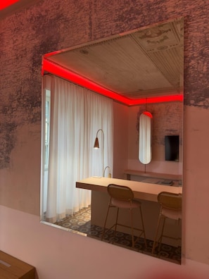 A modern bathroom with a large mirror, a sink, and two stools. - LuxurySuite44: Historic Residence on a Staircase with a Jacuzzi, Located Between Downtown and the Train Station (La Spezia)