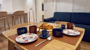 Ein Esstisch mit Tellern, Tassen, einem Croissant und einer Flasche.