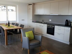 A modern kitchen with white cabinets, a black countertop, and a built-in oven. - Robert 1. OG Süd Appartement/Fewo, Dusche oder Bad, WC by Interhome (Bettmeralp)