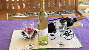 Une bouteille de vin, deux verres à vin et un panier sur une table recouverte d’une nappe violette.