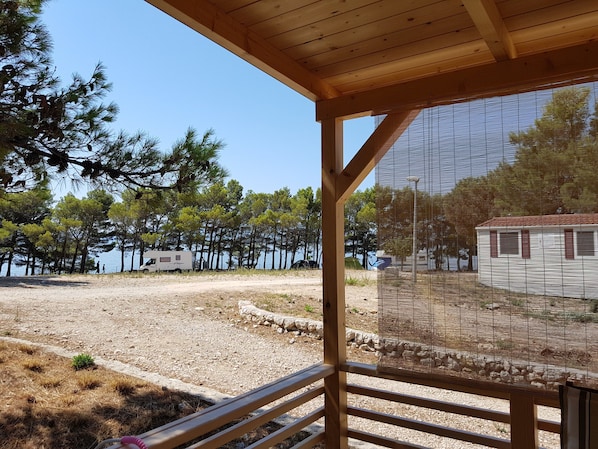 A wooden structure with a view of a beach and trees.
