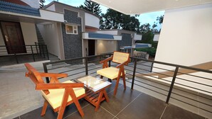 A modern outdoor patio with wooden furniture and a view of a contemporary building.