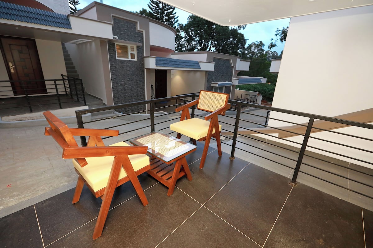 A modern outdoor patio with wooden furniture and a view of a contemporary building.