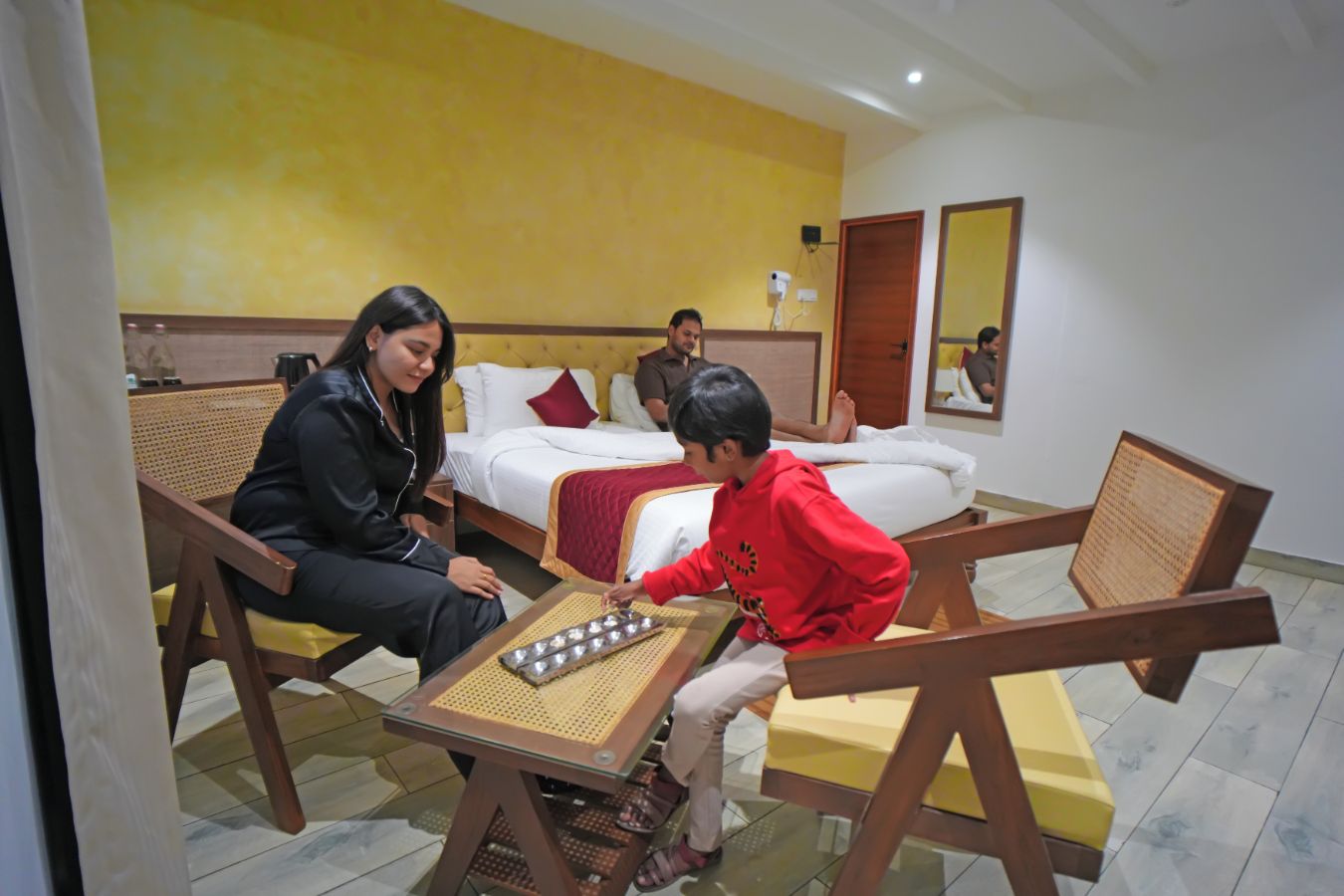 Una camera d'hotel con un letto, un comodino, una sedia e un tavolino con un tappetino.