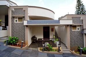 Une maison moderne au design épuré, dotée d’un porche abrité et d’un escalier menant à l’entrée.