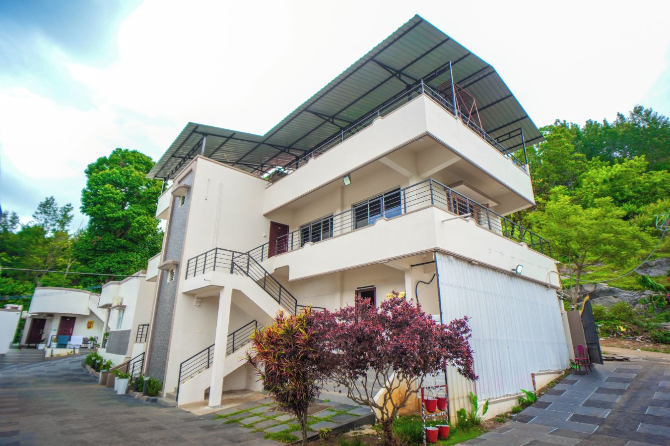 A multi-story residential building with a flat roof and a covered balcony.