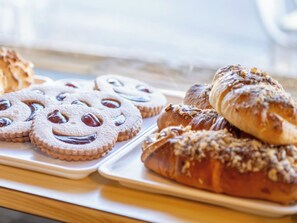 Tarjottimella on monenlaisia leivonnaisia, kuten keksejä ja muita makeita leivoksia.