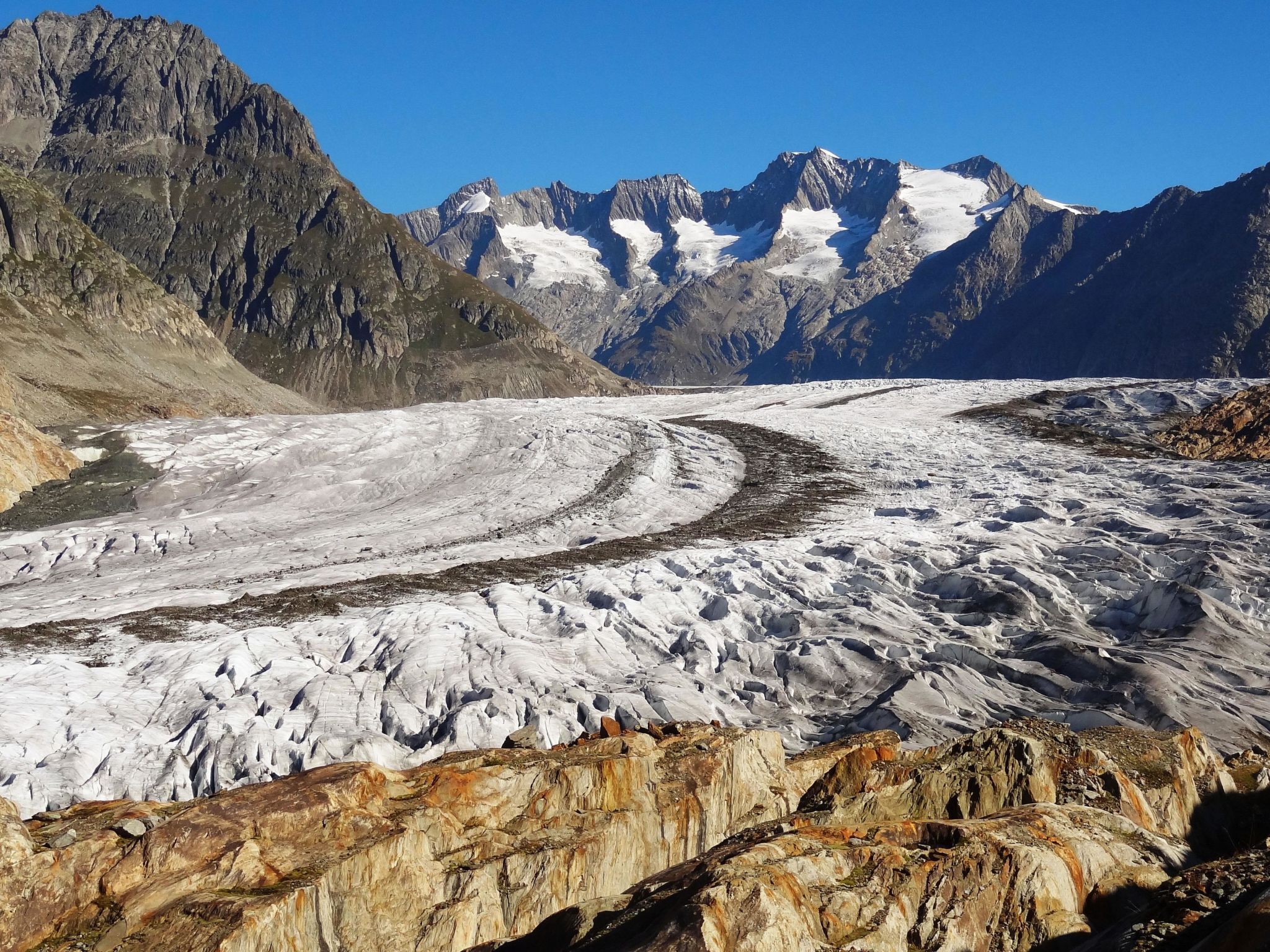 A glacier with rugged mountains in the background.