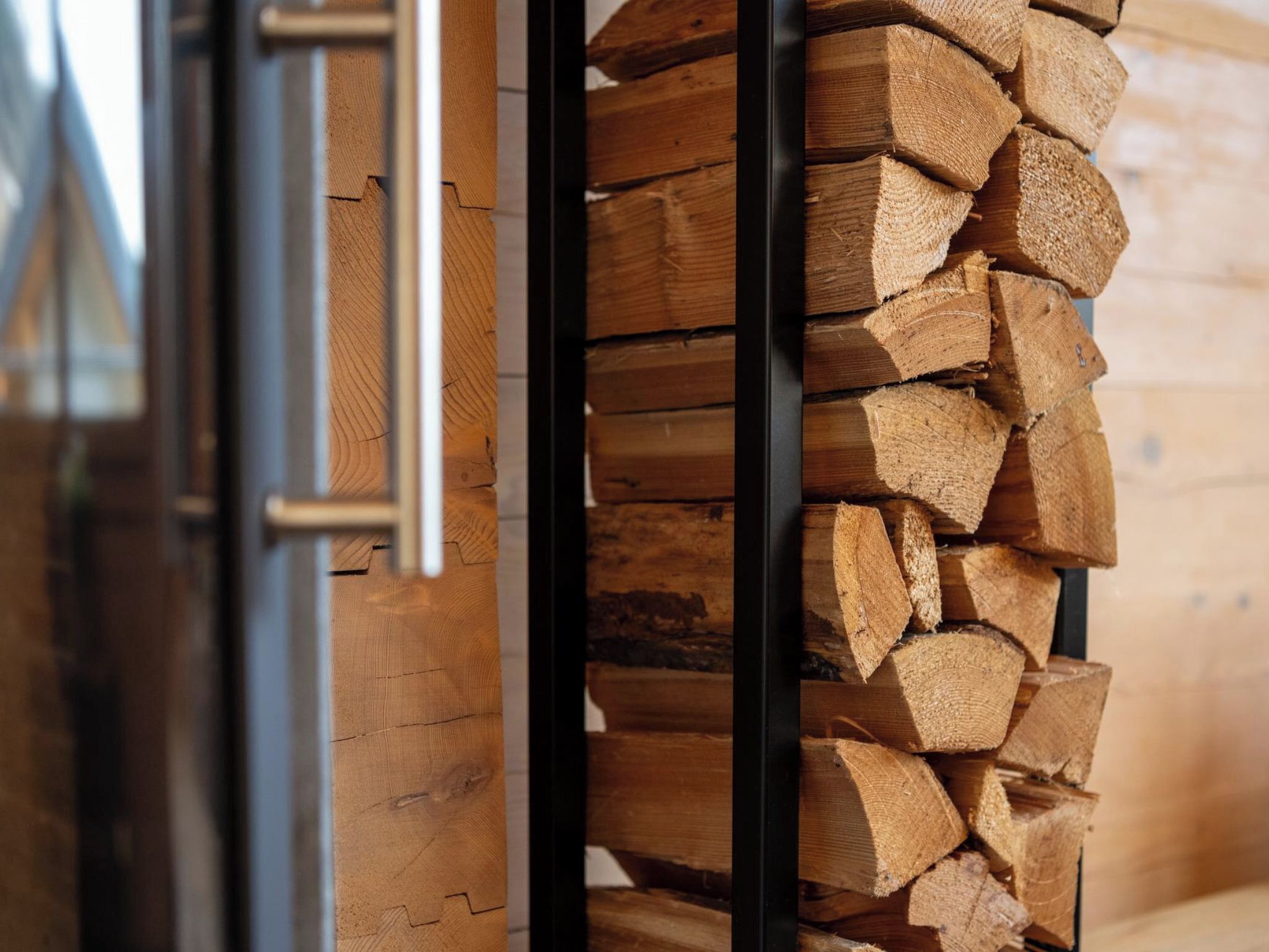 A stack of firewood in a wooden storage area.