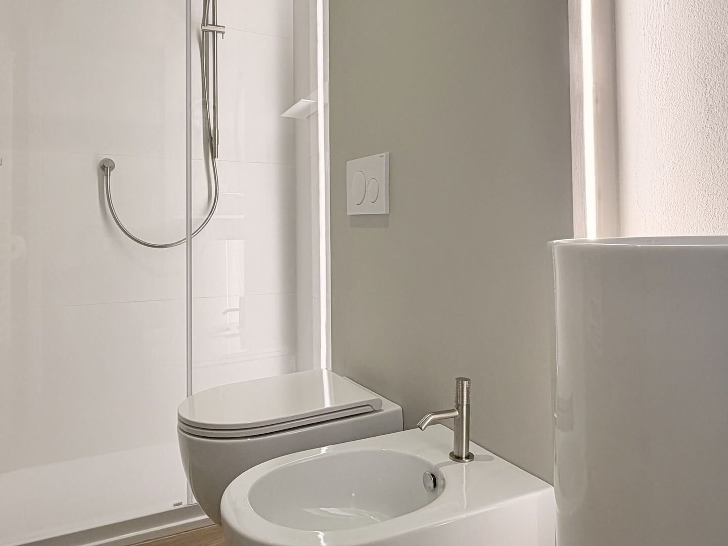 Une salle de bain équipée de toilettes, d’un bidet et d’un lavabo.