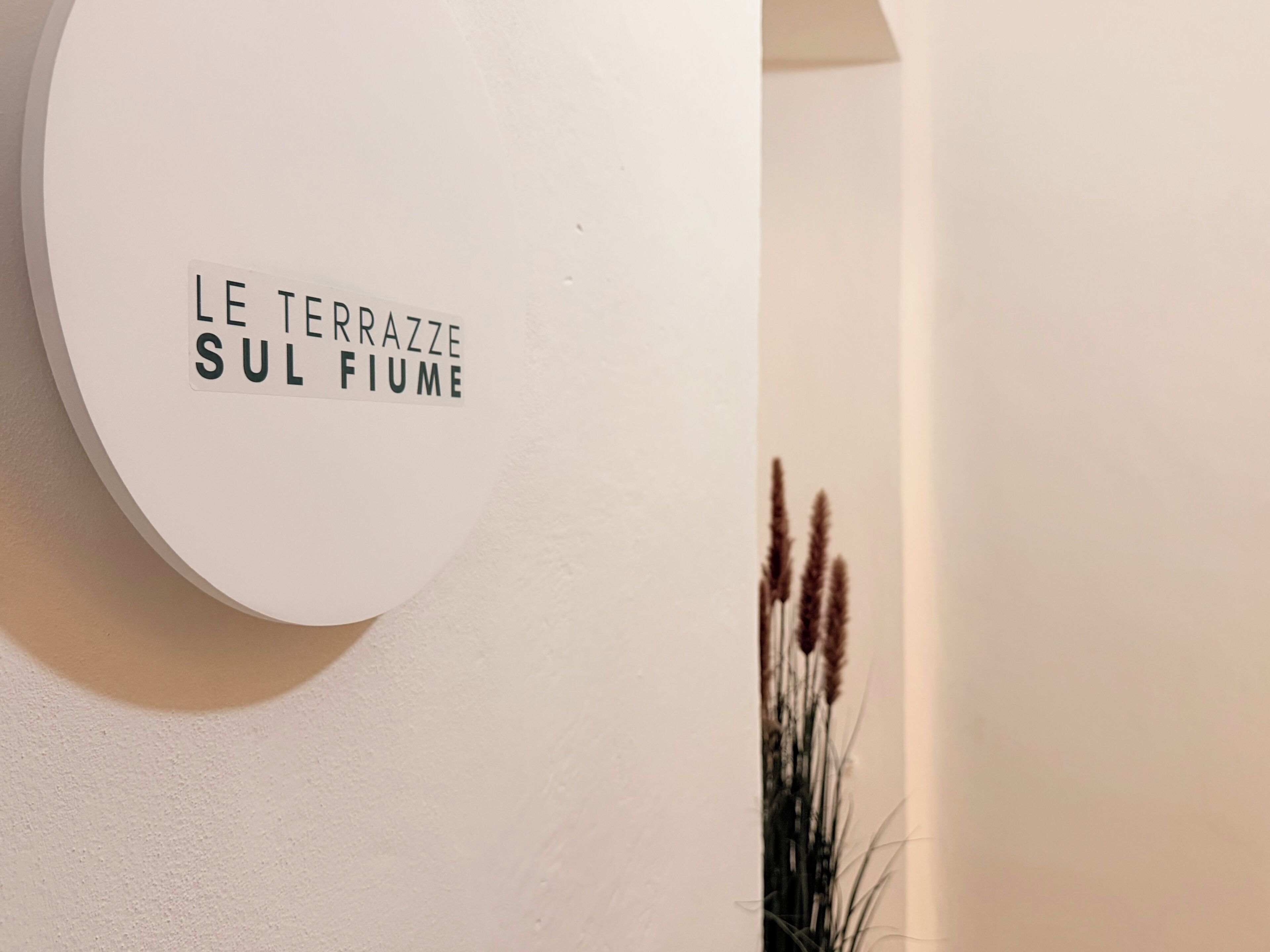 A wall-mounted sign with the text 'LE TERRAZZE SUL FIUME'.