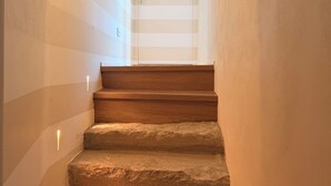 Una escalera con peldaños de madera que conduce a una puerta con un panel de vidrio.
