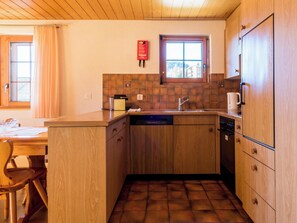 A compact kitchen with wooden cabinets, a built-in dishwasher, and a window with a view. - Südlenz 13 1. OG Süd-West Appartement/Fewo, Bad, WC by Interhome (Riederalp)