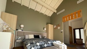 Ein Schlafzimmer mit Bett, Nachttischen, einem Kleiderschrank und einer Bank.